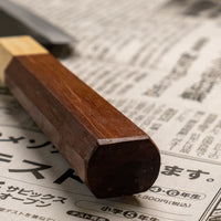 Santoku Funayuki je svestrani kuhinjski nož koji će zablistati u svim vrstama sjeckanja i rezanja. Oštrica je kovana od Suj-2 čelika, tvrdoće 64,7 HRC, jednostavna za brušenje i malo zahtjevnija za održavanje. Tradicionalna japanska (wa) drška izrađena je od temnog palisandera i ima prsten od drva cedrovine.