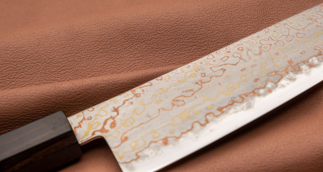 Hayabusa Gyuto Aogami #2 Rainbow Damascus 210 mm je zadivljujući kolekcionarski predmet, izrađen od Aogami #2 čelika, savršeno zadržava svoju oštrinu, a istovremeno ga je lako oštriti. Krasi ga jedinstveni damast uzorak s blagim mat odsjajem, koji je majstorski postignut pažljivim nanošenjem slojeva bakra i mesinga.