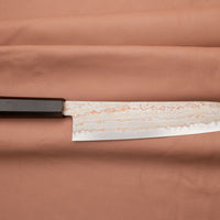 Hayabusa Gyuto Aogami #2 Rainbow Damascus 210 mm je zadivljujući kolekcionarski predmet, izrađen od Aogami #2 čelika, savršeno zadržava svoju oštrinu, a istovremeno ga je lako oštriti. Krasi ga jedinstveni damast uzorak s blagim mat odsjajem, koji je majstorski postignut pažljivim nanošenjem slojeva bakra i mesinga.