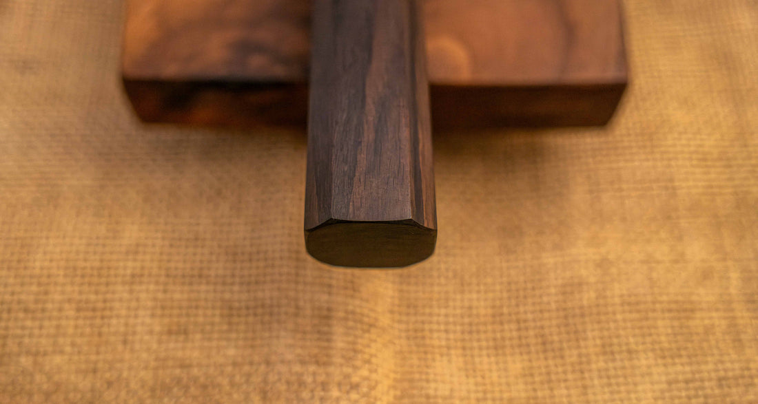Pogled na ročaj Hayabusa Gyuto VG-10 Tsuchime Damascus Ebony 210 mm, izrađen od tamnog ebenovog drva u wa-stilu, pruža udoban i stabilan zahvat za potpunu kontrolu prilikom rezanja.