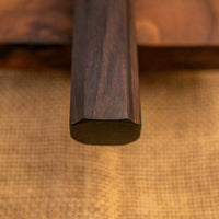 Pogled na ročaj Hayabusa Gyuto VG-10 Tsuchime Damascus Ebony 210 mm, izrađen od tamnog ebenovog drva u wa-stilu, pruža udoban i stabilan zahvat za potpunu kontrolu prilikom rezanja.