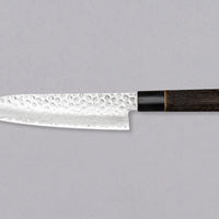 Kawamura Santoku Damascus svestrani je japanski kuhinjski nož. Jezgra je izrađena od čelika AUS-10 i obavijena u slojeve damaščanskog čelika. Gornji dio oštrice krase otisci čekića. Tradicionalna japanska drška izrađena je od paljenog drva kestena s prstenom od bivoljeg roga.