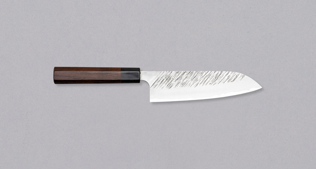 Kurosaki santoku iz linije Fujin još je jedan jedinstveni nož iz ruku talentiranog mladog kovača Yu Kurosakija. Jedinstvene linije na oštrici podsjećaju na vjetar, zbog čega je i ova linija dobila ime po Fujinu, japanskom bogu vjetra. Nož ima tradicionalnu japansku dršku od palisandera. Optimalan za svakodnevnu upotrebu.