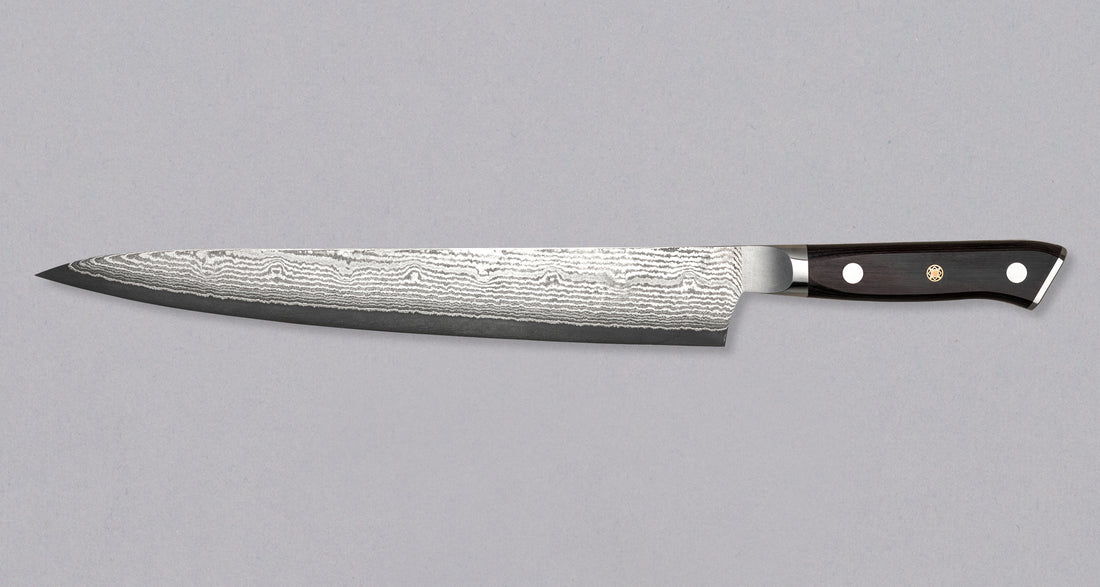 Mcusta Zanmai Sujihiki VG-10 Black Damascus japanski je nož namijenjen za rezanje tankih kriški mesa i ribe. Tvrda jezgra od nehrđajućeg VG-10 čelika (61 HRC) s san-mai laminacijom s mekšim čelikom čini 33 sloja čelika, vidljiva u crnom damast uzorku. Nož ima crnu zapadnjačku dršku od pakka drva s mozaičkom zakovicom.