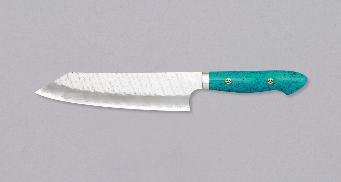Nigara Kiri-Gyuto SG2 Migaki Tsuchime Turquoise 210 mm višenamjenski je japanski kuhinjski nož, pogodan za pripremu mesa, ribe i povrća. Jezgra od SG2 praškastog čelika i hamaguri presjek profila osiguravaju dugotrajnu oštrinu i minimalno održavanje. Odrezani kiritsuke vršak pomaže nam pregledati i precizno rezati hranu.