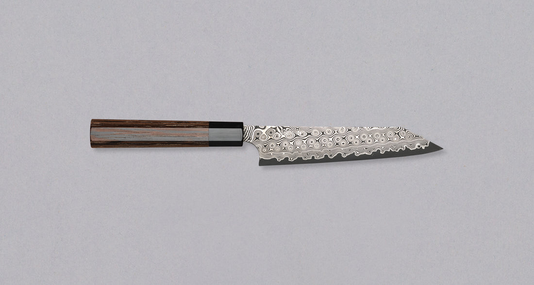 Nigara Kiritsuke Petty SG2 Damascus 150 mm je mali kuhinjski nož za upotrebu kuhinjskih poslova, kod kojih bi veći nož bio nespretan. Jezgra od praškastog čelika SG2 i hamaguri presjek profila jamstvo su dugotrajne oštrine i minimalnog održavanja. Kružni uzorak na oštrici poznat je i kao amatsubu ili uzorak kišnih kapi.