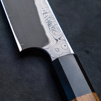Nigara Kurozome Kiritsuke Yanagiba Aogami #2 Damascus 240 mm tradicionalni je japanski nož koji se koristi za pripremu ribe (osobito za sašimi i nigiri suši). Duga oštrica omogućuje lijepe i duge pokrete, a podrezan vršak precizan završetak reza.