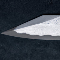 Nigara Kurozome Kiritsuke Yanagiba Aogami #2 Damascus 240 mm tradicionalni je japanski nož koji se koristi za pripremu ribe (osobito za sašimi i nigiri suši). Duga oštrica omogućuje lijepe i duge pokrete, a podrezan vršak precizan završetak reza.