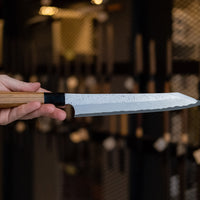 Nigara Kurozome Kiritsuke Yanagiba Aogami #2 Damascus 240 mm tradicionalni je japanski nož koji se koristi za pripremu ribe (osobito za sašimi i nigiri suši). Duga oštrica omogućuje lijepe i duge pokrete, a podrezan vršak precizan završetak reza.