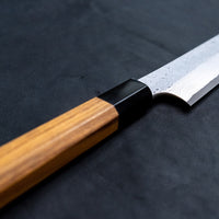 Nigara Kurozome Kiritsuke Yanagiba Aogami #2 Damascus 240 mm tradicionalni je japanski nož koji se koristi za pripremu ribe (osobito za sašimi i nigiri suši). Duga oštrica omogućuje lijepe i duge pokrete, a podrezan vršak precizan završetak reza.