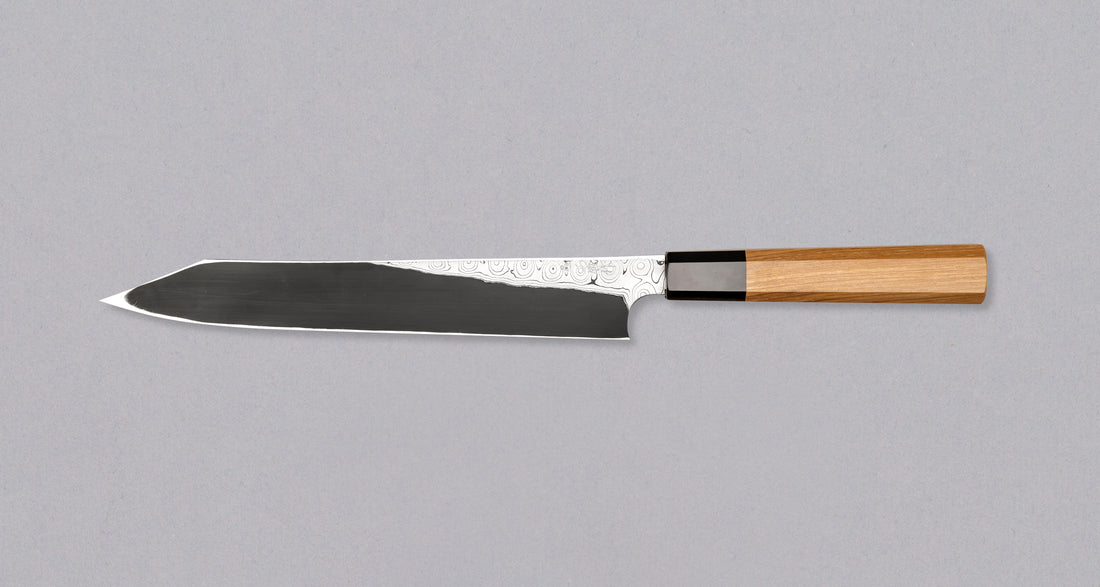 Nigara Kurozome Kiritsuke Yanagiba Aogami #2 Damascus 240 mm tradicionalni je japanski nož koji se koristi za pripremu ribe (osobito za sašimi i nigiri suši). Duga oštrica omogućuje lijepe i duge pokrete, a podrezan vršak precizan završetak reza.