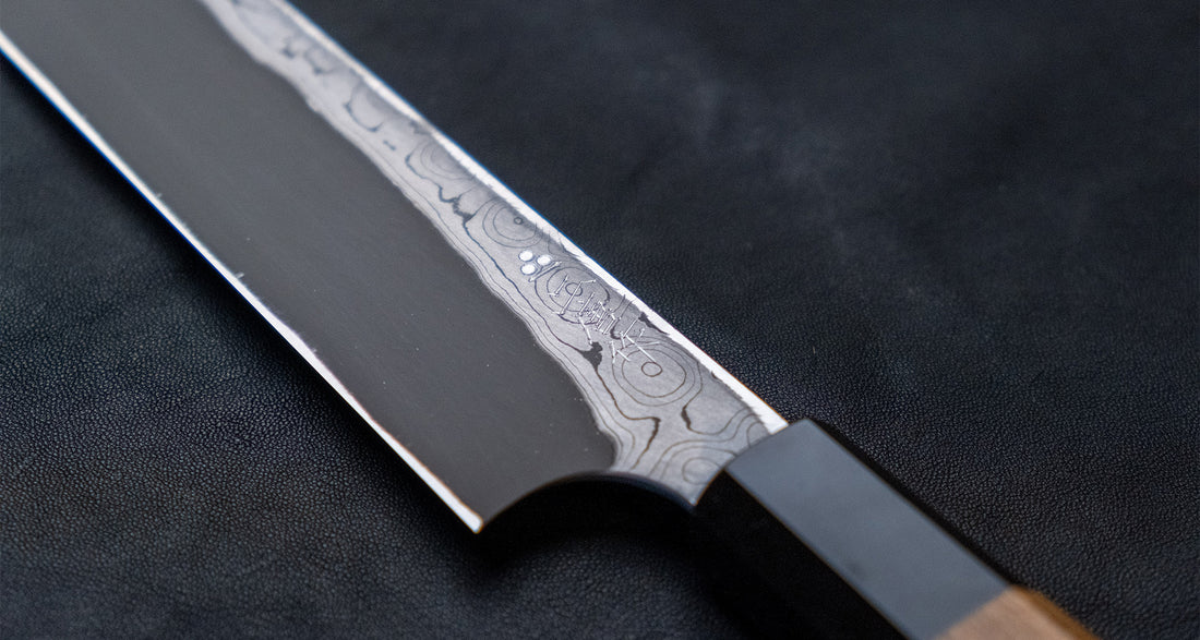 Nigara Kurozome Kiritsuke Yanagiba Aogami #2 Damascus 270 mm tradicionalni je japanski nož koji se koristi za pripremu ribe, posebno za sašimi i nigiri suši. Duljina noža omogućuje korisniku rezanje ribljeg filea jednim potezom, što zajedno s jednostrano brušenom oštricom doprinosi briljantno glatkim kriškama sašimija.