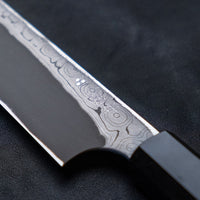 Nigara Kurozome Kiritsuke Yanagiba Aogami #2 Damascus 270 mm tradicionalni je japanski nož koji se koristi za pripremu ribe, posebno za sašimi i nigiri suši. Duljina noža omogućuje korisniku rezanje ribljeg filea jednim potezom, što zajedno s jednostrano brušenom oštricom doprinosi briljantno glatkim kriškama sašimija.