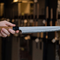 Nigara Kurozome Kiritsuke Yanagiba Aogami #2 Damascus 270 mm tradicionalni je japanski nož koji se koristi za pripremu ribe, posebno za sašimi i nigiri suši. Duljina noža omogućuje korisniku rezanje ribljeg filea jednim potezom, što zajedno s jednostrano brušenom oštricom doprinosi briljantno glatkim kriškama sašimija.
