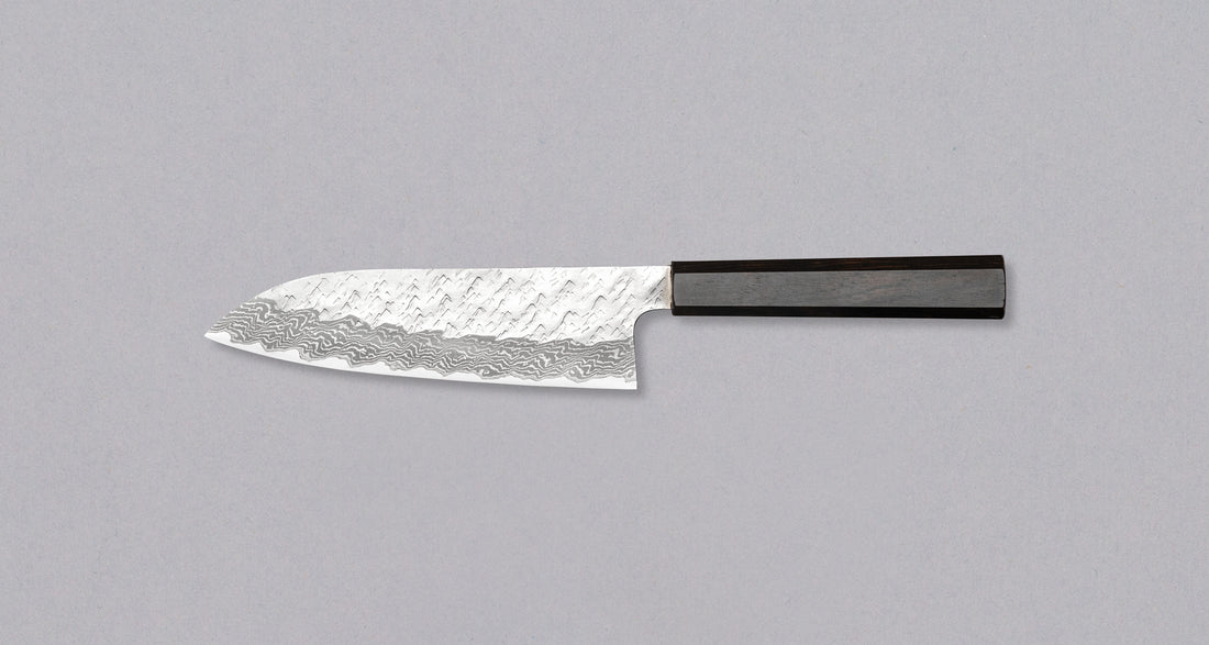 Nigara Santoku VG-10 Damascus Tsuchime 180 mm višenamjenski je japanski kuhinjski nož pogodan za pripremu mesa, ribe i povrća. Jezgra od nehrđajućeg čelika VG-10 garancija je za  dugotrajnu oštrinu i minimalno održavanje. Iznimne karakteristike i izgled noža nadopunjuje drška japanskog tipa (Wa), izrađena od luksuzne ebanovine.