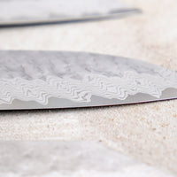 Nigara Santoku VG-10 Damascus Tsuchime 180 mm višenamjenski je japanski kuhinjski nož pogodan za pripremu mesa, ribe i povrća. Jezgra od nehrđajućeg čelika VG-10 garancija je za  dugotrajnu oštrinu i minimalno održavanje. Iznimne karakteristike i izgled noža nadopunjuje drška japanskog tipa (Wa), izrađena od luksuzne ebanovine.