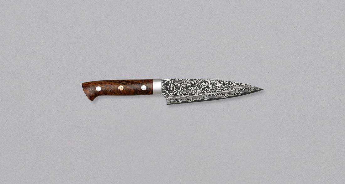 Saji Petty R2 Ironwood 130 mm impresivan je tako u svakom pogledu. Oduševljava nas ne samo svojom vizualnom slikom, već i izvrsnim specifikacijama. Jezgra ovog noža izrađena je od R2/SG2 praškastog čelika tvrdoće 63-64 HRC, a okružena je slojevima nehrđajućeg čelika koji mu daju jedinstven tamni damaščanski uzorak.