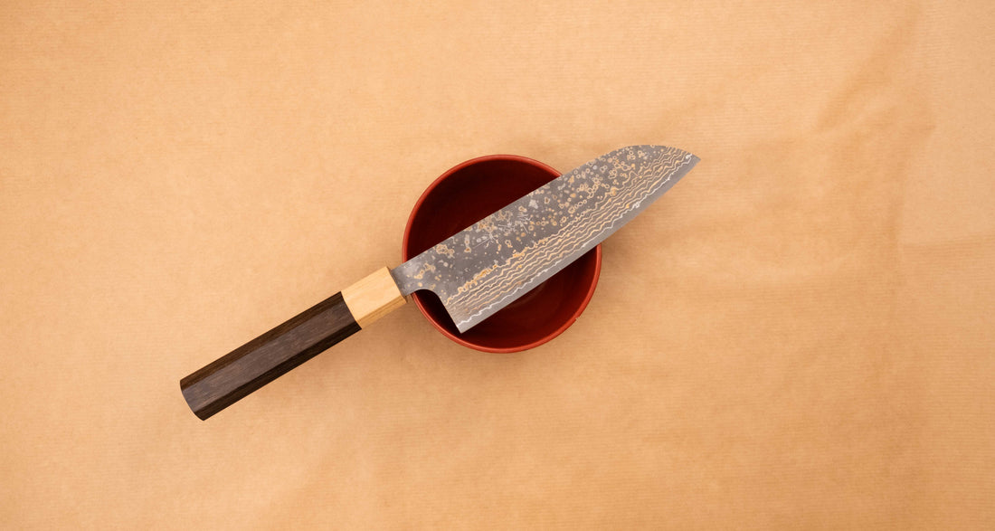 Saji Santoku VG-10 Gold RWO 165 mm je svestrani japanski kuhinjski nož, prikladan za pripremu mesa, ribe i povrća. Međutim, činili bismo mu krivo kad bismo ga nazvali samo kuhinjskim nožem jer on je zaista izniman primjer japanske kovačke vještine – od njegovog izgleda pa sve do specifičnih detalja.
