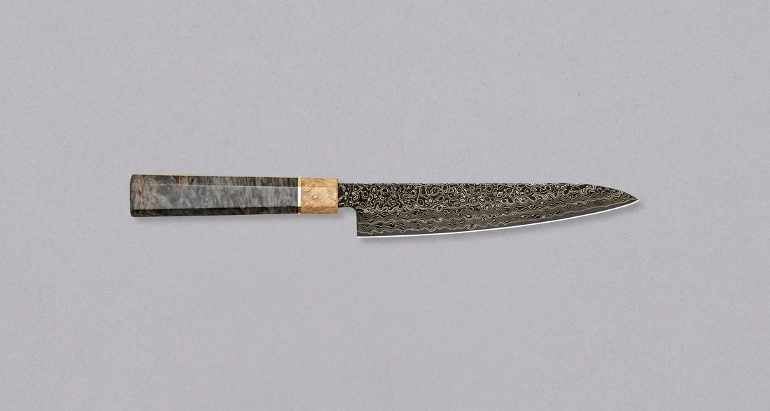 Senzo Dawn Limited Edition Petty SG2 mali je višenamjenski japanski kuhinjski nož kovačnice Suncraft. Jezgra je od SG2 praškastog čelika (62-63 HRC) tako da će dugo ostati oštar. Osmerokutna drška ukrašena je završnim prstenom od posebnog drva 300 godina starog svetog hrasta. To je zadivljujući kolekcionarski predmet.