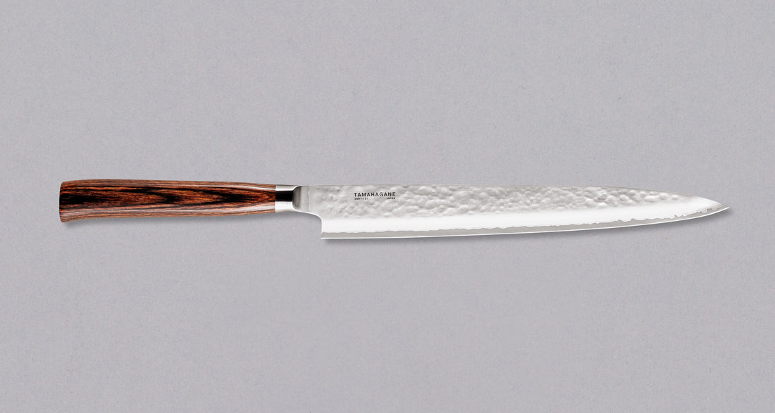 Tamahagane "TSUBAME" Sashimi-Slicer 240 mm Sashimi-SLicer 240 mm: Duga i uska oštrica je prikladna za rezanje tankih komada mesa i ribe. Ovaj je nož izvrstan za žar i sushi majstore te za sve ljubitelje odličnih odrezaka! Noževe Tamahagane izrađuju u Nigati u Japanu, u regiji poznatoj po proizvodima od čelika. Napravljeni su na tradicionalan način uz upotrebu moderne tehnologije.