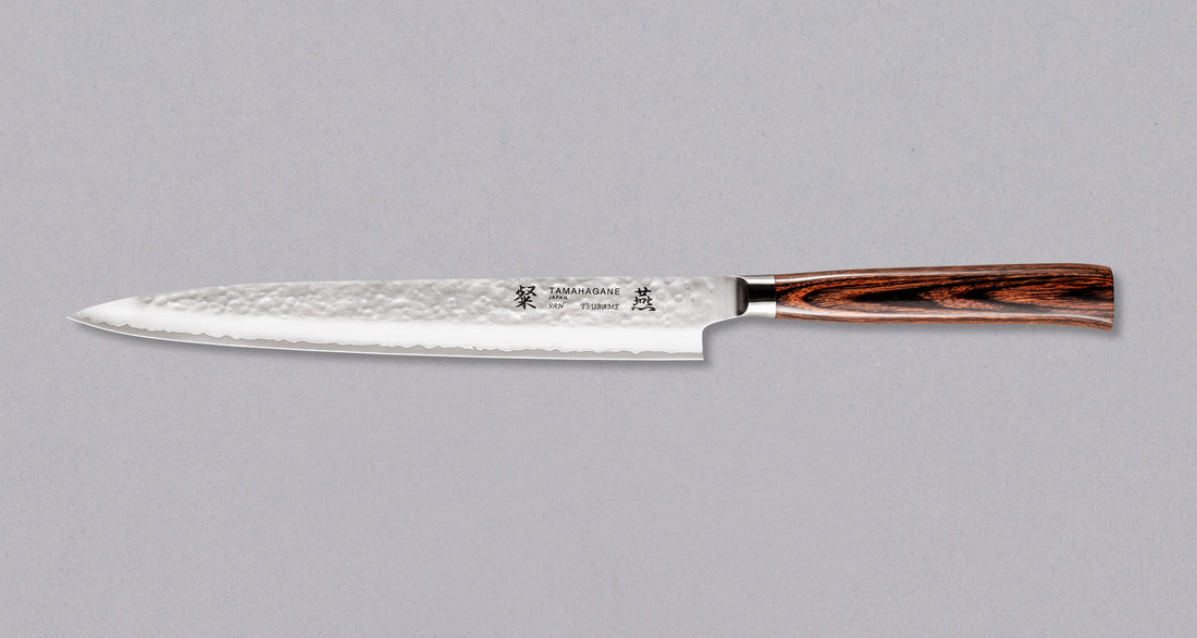 Tamahagane "TSUBAME" Sashimi-Slicer 240 mmSashimi-SLicer 240 mm: Duga i uska oštrica je prikladna za rezanje tankih komada mesa i ribe. Ovaj je nož izvrstan za žar i sushi majstore te za sve ljubitelje odličnih odrezaka! Noževe Tamahagane izrađuju u Nigati u Japanu, u regiji poznatoj po proizvodima od čelika. Napravljeni su na tradicionalan način uz upotrebu moderne tehnologije.