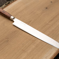 Sashimi-SLicer 240 mm: Duga i uska oštrica je prikladna za rezanje tankih komada mesa i ribe. Ovaj je nož izvrstan za žar i sushi majstore te za sve ljubitelje odličnih odrezaka! Noževe Tamahagane izrađuju u Nigati u Japanu, u regiji poznatoj po proizvodima od čelika. Napravljeni su na tradicionalan način uz upotrebu moderne tehnologije.