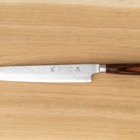 Sashimi-SLicer 240 mm: Duga i uska oštrica je prikladna za rezanje tankih komada mesa i ribe. Ovaj je nož izvrstan za žar i sushi majstore te za sve ljubitelje odličnih odrezaka! Noževe Tamahagane izrađuju u Nigati u Japanu, u regiji poznatoj po proizvodima od čelika. Napravljeni su na tradicionalan način uz upotrebu moderne tehnologije.
