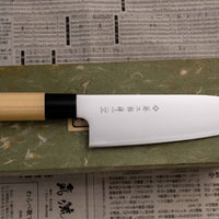 Tojiro Santoku Zen nož je renomiranog proizvođača Tojiro kojeg karakterizira japanska drška od magnolije, minimalistički oblikovana oštrica i tvrda legura čelika. Rezultat svega toga je lagan, oštar, svestran kuhinjski nož za amaterske i profesionalne kuhare, s oštricom koja je vrlo otporna na hrđu i jednostavno ju je ponovno brusiti.