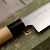 Tojiro Santoku Zen nož je renomiranog proizvođača Tojiro kojeg karakterizira japanska drška od magnolije, minimalistički oblikovana oštrica i tvrda legura čelika. Rezultat svega toga je lagan, oštar, svestran kuhinjski nož za amaterske i profesionalne kuhare, s oštricom koja je vrlo otporna na hrđu i jednostavno ju je ponovno brusiti.