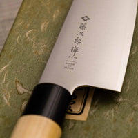Tojiro Santoku Zen nož je renomiranog proizvođača Tojiro kojeg karakterizira japanska drška od magnolije, minimalistički oblikovana oštrica i tvrda legura čelika. Rezultat svega toga je lagan, oštar, svestran kuhinjski nož za amaterske i profesionalne kuhare, s oštricom koja je vrlo otporna na hrđu i jednostavno ju je ponovno brusiti.