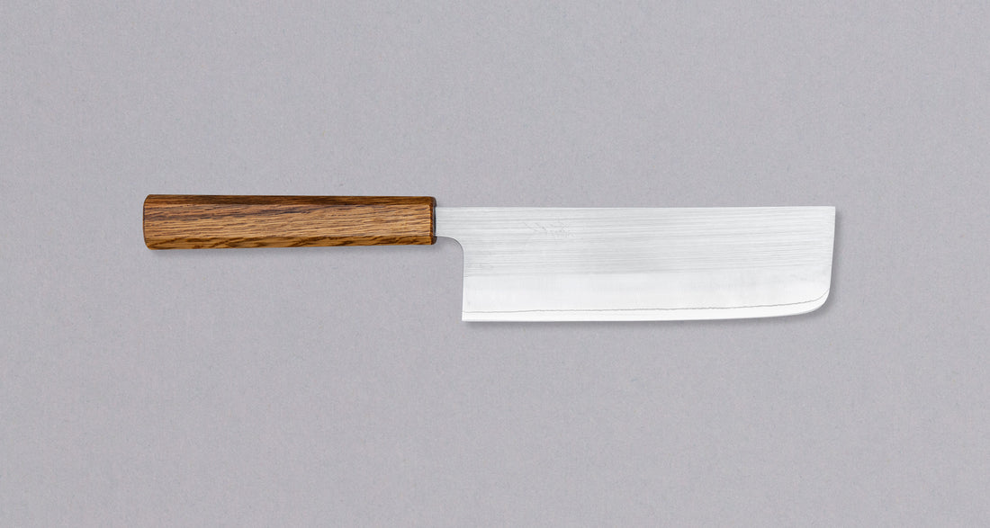 Niti jedno povrće ne može se suprostaviti iznimno oštrim i tvrdim (64 HRC!) Tsunehisa SRS13 Nakiri Oak 165 mm. Zbog širokog profila i tankog konkavnog oštrenja, oštrica je vrhunska pri pripremi svih vrsta povrća. Savršen odabir za ljetne salate! 🥗 Zahvaljujući minimalističkom japanskom dizajnu, ovaj iznimno lagani nož nikada neće izaći iz mode. Tsunehisa SRS13 Nakiri Oak 165 mm. Nova klasika.