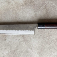 Hokiyama Ginsanko Rosewood Kiritsuke 210 mm_2 Kiritsuke je višenamjenski japanski kuhinjski nož - dužina 210 mm optimalna je za sjeckanje povrća i rezanje većih komada mesa. Srce noža je Silver Steel III čelik, tvrdoće cca 63 HRC koji zovu još i Ginsan Steel ili Ginsanko. Glavna osobina ovog čelika je da se odlično suprotstavlja hrđanju.