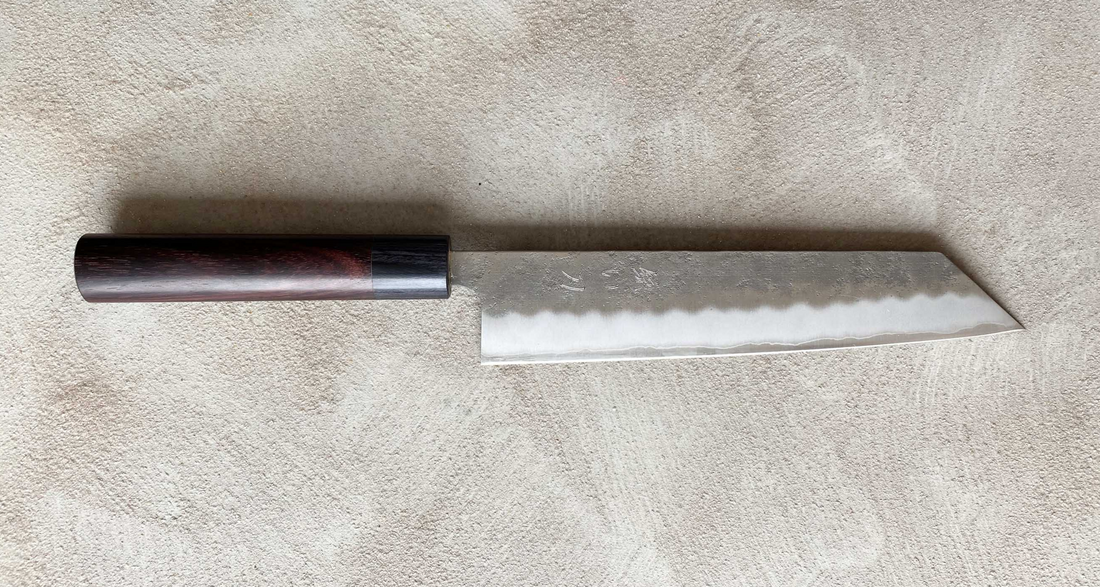 Hokiyama Ginsanko Rosewood Kiritsuke 210 mm_3  Kiritsuke je višenamjenski japanski kuhinjski nož - dužina 210 mm optimalna je za sjeckanje povrća i rezanje većih komada mesa. Srce noža je Silver Steel III čelik, tvrdoće cca 63 HRC koji zovu još i Ginsan Steel ili Ginsanko. Glavna osobina ovog čelika je da se odlično suprotstavlja hrđanju.