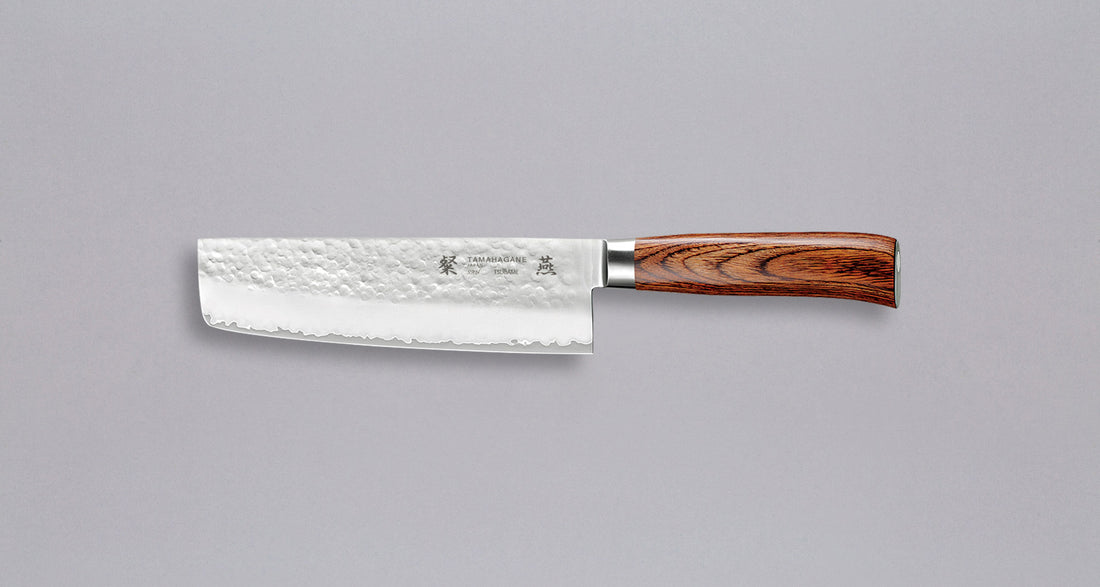 Tamahagane "TSUBAME" Nakiri 180 mm_1Tamahagane San Nakiri 180 mm je japanski nož za rezanje povrća. Nož će blistati prilikom sjeckanja i rezanja na kuhinjskoj dasci. Za domaću te profesionalnu upotrebu, nezamjenjiv za ljubitelje povrća. Noževe Tamahagane izrađuju u Nigati u Japanu, u regiji poznatoj po proizvodima od čelika. Napravljeni su na tradicionalan način uz upotrebu moderne tehnologije.