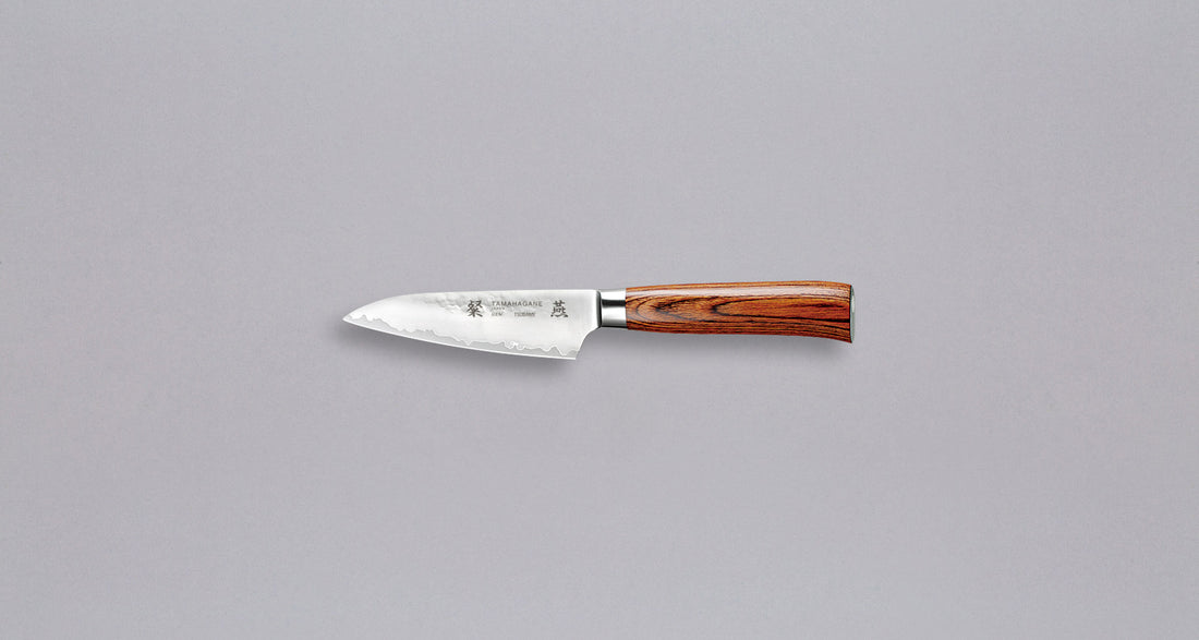 Tamahagane "TSUBAME" Paring 90 mm_1Tamahagane San Petty 90 mm je mali kuhinjski nož koji upotrebljavamo za ljuštenje povrća, rezanje voća i sjeckanje začina na kuhinjskoj dasci. Noževe Tamahagane izrađuju u Nigati u Japanu, u regiji poznatoj po proizvodima od čelika. Napravljeni su na tradicionalan način uz upotrebu moderne tehnologije.