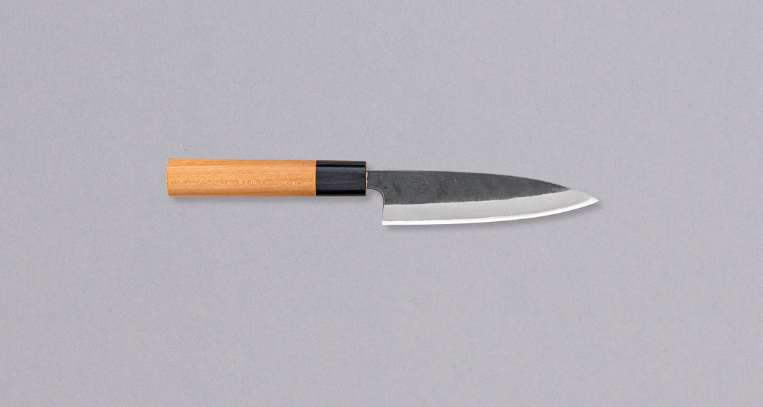 Muneishi Petty Aogami #2 Kuro-uchi 120 mm svestrani je japanski kuhinjski nož, koji možemo upotrebljavati za sve vrste guljenja povrća, obrezivanja voća, sjeckanja začinskih biljaka na daski. Oštrica će s lakoćom kliziti kroz namirnice, a rezovi će biti iznimno čisti, zahvaljujući finoj oštrini koju tvrda jezgra od Aogami #2 čelika može postići. Svojstva noža, glatki rezovi i autentičan izgled uvjerit će svakoga entuzijasta u njegovu oštrinu.