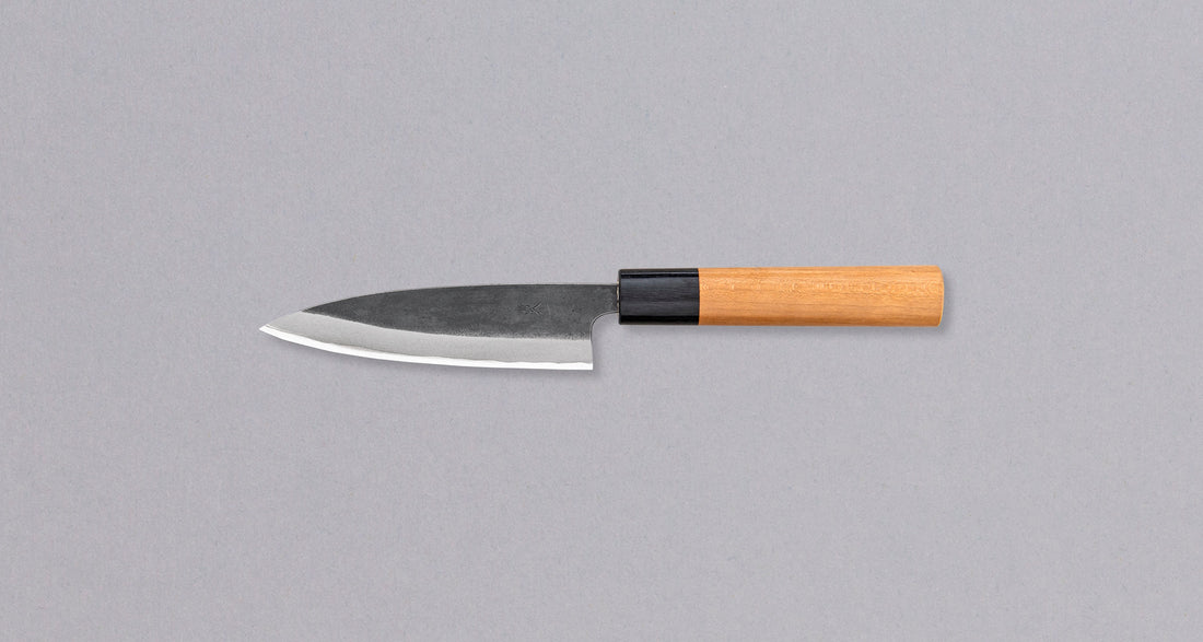 Muneishi Petty Aogami #2 Kuro-uchi 120 mm svestrani je japanski kuhinjski nož, koji možemo upotrebljavati za sve vrste guljenja povrća, obrezivanja voća, sjeckanja začinskih biljaka na daski. Oštrica će s lakoćom kliziti kroz namirnice, a rezovi će biti iznimno čisti, zahvaljujući finoj oštrini koju tvrda jezgra od Aogami #2 čelika može postići. Svojstva noža, glatki rezovi i autentičan izgled uvjerit će svakoga entuzijasta u njegovu oštrinu.