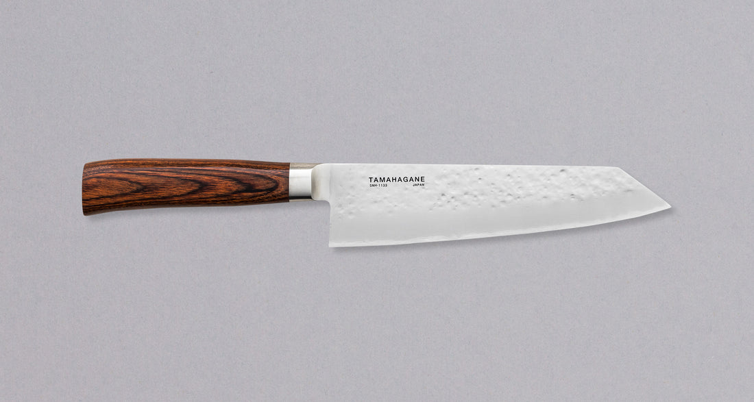 Tamahagane "TSUBAME" Kengata 190 mm_2Tamahagane San Kengata 190 mm ili Bunka je svestran kuhinjski nož koji će blistati prilikom sjeckanja i rezanja na kuhinjskoj dasci. Veličina oštrice je 190 mm.  Noževe Tamahagane izrađuju u Nigati u Japanu, u regiji poznatoj po proizvodima od čelika. Napravljeni su na tradicionalan način uz upotrebu moderne tehnologije.