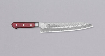 Tsunehisa Gyuto AS Tsuchime 240 mm svestrani je japanski kuhinjski nož za pripremu mesa, ribe i povrća. Gyuto u prijevodu znači 'goveđi mač' što govori o njegovoj naklonjenosti rezanju mesa. Pogotovo duži gyuto noževi – poput ovog ljepotana iz kovačnice Tshunehisa – posebno zablistaju pri rezanju većih komada mesa i pripremi sašimija, izvrsni su, naravno, i pri pripremi svih ostalih namirnica.