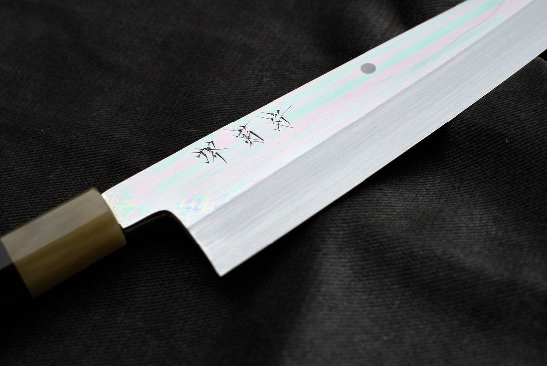 Kawamura Mizu-Honyaki Gyuto Shirogami #2 240 mm ručno kovan nož, izrađen nevjerojatno precizno, kao rezultat stoljetnih iskustava i učenja, grešaka i uspjeha. Radi se o nožu u kojem se prepliću izvrstan alat i umjetničko dijelo.