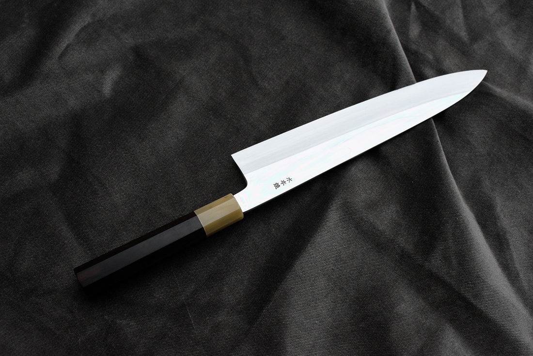 Kawamura Mizu-Honyaki Gyuto Shirogami #2 240 mm ručno kovan nož, izrađen nevjerojatno precizno, kao rezultat stoljetnih iskustava i učenja, grešaka i uspjeha. Radi se o nožu u kojem se prepliću izvrstan alat i umjetničko dijelo.