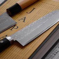 Etsu Village Santoku Damascus Black 170 mm_4  Ručno kovan Kunio Masutani damask nož. Santoku koristi se za rezanje povrća, ribe i mesa. Oblik i dužina su primjerni za manji svestrani kuhinjski nož koji će zablistati prilikom rezanja i sjeckanja na kuhinjskoj dasci. Za domaću te profesionalnu upotrebu.
