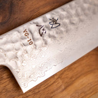 Detaljan prikaz površine i teksture noža Hayabusa Santoku VG-10 Tsuchime Damascus Ebony 180 mm, s prepoznatljivim damask uzorkom i čekićem otisnutom teksturom, koja smanjuje lijepljenje hrane na oštricu