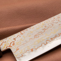 Hayabusa Gyuto Aogami #2 Rainbow Damascus 210 mm je zadivljujući kolekcionarski predmet, izrađen od Aogami #2 čelika, savršeno zadržava svoju oštrinu, a istovremeno ga je lako oštriti. Krasi ga jedinstveni damast uzorak s blagim mat odsjajem, koji je majstorski postignut pažljivim nanošenjem slojeva bakra i mesinga. 