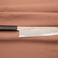 Hayabusa Gyuto Aogami #2 Rainbow Damascus 210 mm je zadivljujući kolekcionarski predmet, izrađen od Aogami #2 čelika, savršeno zadržava svoju oštrinu, a istovremeno ga je lako oštriti. Krasi ga jedinstveni damast uzorak s blagim mat odsjajem, koji je majstorski postignut pažljivim nanošenjem slojeva bakra i mesinga. 