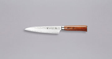 Tamahagane San Petty 150 mm je mali kuhinjski nož koji upotrebljavamo za ljuštenje povrća, rezanje voća i sjeckanje začina na kuhinjskoj dasci. Noževe Tamahagane izrađuju u Nigati u Japanu, u regiji poznatoj po proizvodima od čelika. Napravljeni su na tradicionalan način uz upotrebu moderne tehnologije. 