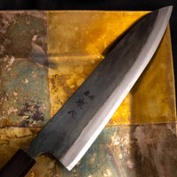 Detaljan prikaz kuro-uchi površine, kanji gravura i pete noža Kokugei Gyuto Aogami #1 Kuro-uchi Ebony 210 mm, naglašavajući ručno kovani karakter.