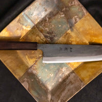 Kokugei Gyuto Aogami #1 Kuro-uchi Ebony 210 mm svestrani je japanski kuhinjski nož namijenjen pripremi mesa, ribe i povrća. Nož ima distalno suženu pozadinu i rustikalnu crnu kuro-uchi površinsku obradu koja odražava tradicionalnu estetiku ručno kovanih japanskih noževa.