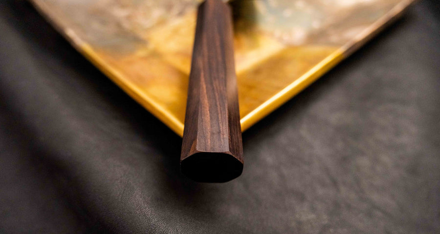 Prikaz osemokutne ručke od tamnog drveta ebanovine na Kokugei Gyuto Aogami #1 Kuro-uchi Ebony 210 mm nožu, koja osigurava stabilan i udoban hvat.