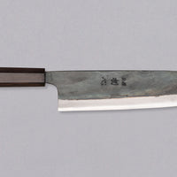 Kokugei Gyuto Aogami #1 Kuro-uchi Ebony 240 mm svestrani je japanski kuhinjski nož namijenjen pripremi mesa, ribe i povrća. Nož ima distalno suženu pozadinu i rustikalnu crnu kuro-uchi površinsku obradu koja odražava tradicionalnu estetiku ručno kovanih japanskih noževa.